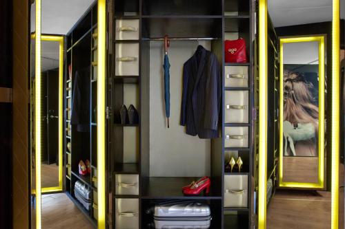 a walk in closet with a mirror and red shoes at W London in London