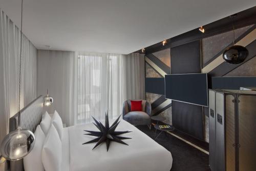 a hotel room with a bed and a chair at W London in London