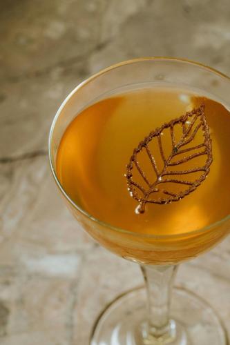 a glass of tea with a butterfly on it at W London in London