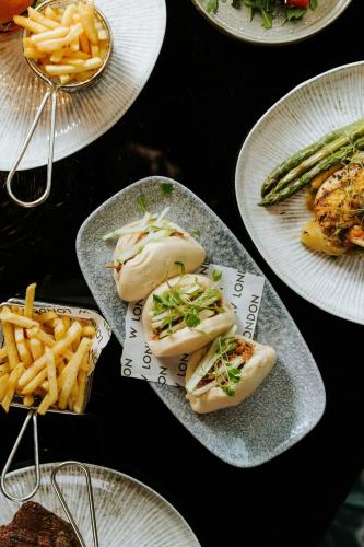 a table topped with plates of food and french fries at W London in London