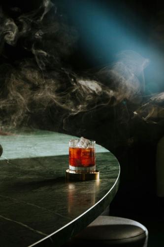 a drink sitting on a table with smoke at W London in London