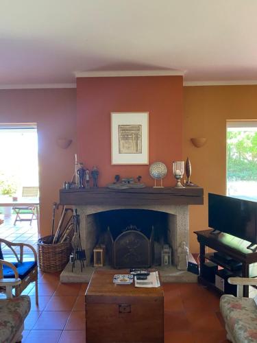 a living room with a fireplace and a table at Casa do Campo - Castelo Branco in Castelo Branco