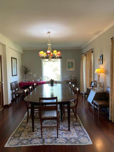 a dining room and living room with a table and chairs at Casa do Campo - Castelo Branco in Castelo Branco