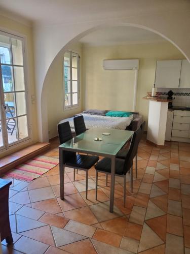 un salon avec une table et des chaises et un lit dans l'établissement Le Pin Doré, à Antibes