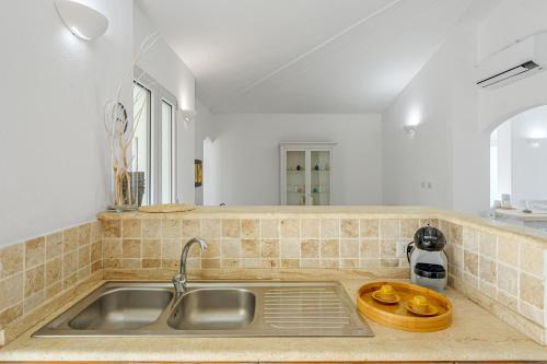 a kitchen with a sink and a counter top at VILLA LA MADDALENA 6&2, Emma Villas in Arzachena
