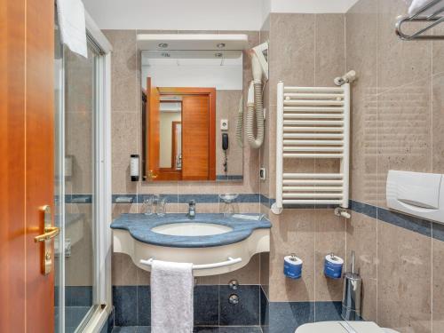 a bathroom with a sink and a mirror at B&B HOTELS Hotel Prestige Ornago in Ornago