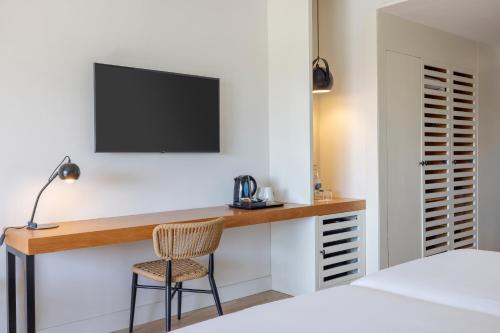 a bedroom with a desk with a tv and a chair at AluaSoul Costa Adeje - Adults Only in Adeje