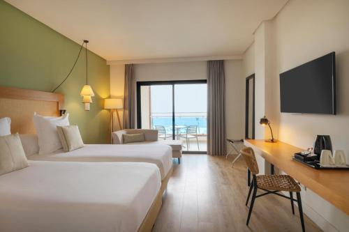 a hotel room with two beds and a desk at AluaSoul Costa Adeje - Adults Only in Adeje