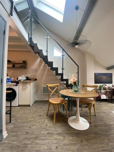 une pièce avec une table, des chaises et un escalier dans l'établissement Stylish & Cosy Mezzanine in Historical Old Town, à Annecy