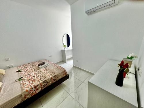 a bedroom with a bed and a table with a vase of flowers at 4 bedroom with swimming pool in Fgura