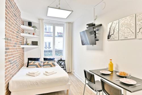 Ce petit appartement comprend un lit et une table à manger. dans l'établissement Small, cozy and centrally #marsh studio - III, à Paris