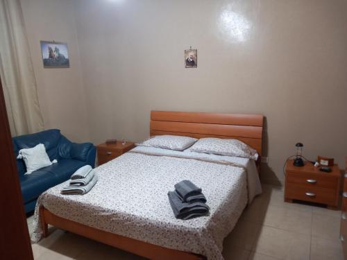a bedroom with a bed and a blue chair at Paradiso House in Torre Ovo
