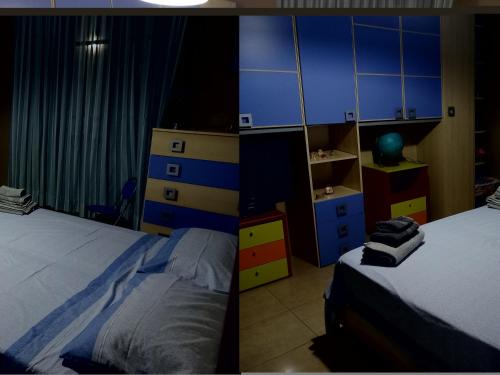 a bedroom with two beds and blue and yellow cabinets at Paradiso House in Torre Ovo