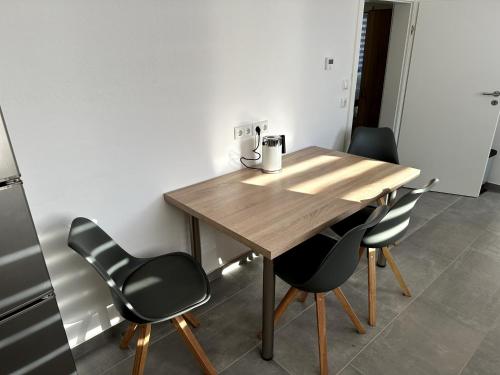 a wooden table with chairs and a tea kettle on it at Monteurzimmer bei Jena - T und T GbR in Bucha