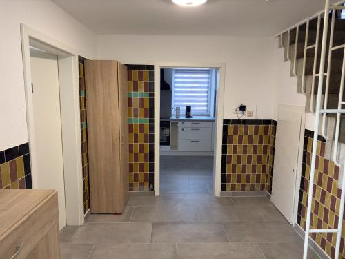 a room with a hallway with a kitchen and a room with tiles at Monteurzimmer bei Jena - T und T GbR in Bucha