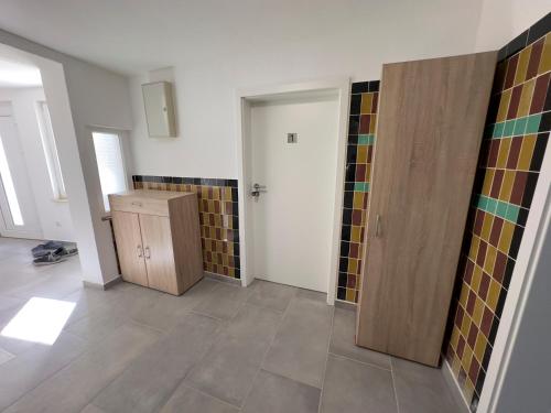 an empty room with a door and tiles on the walls at Monteurzimmer bei Jena - T und T GbR in Bucha