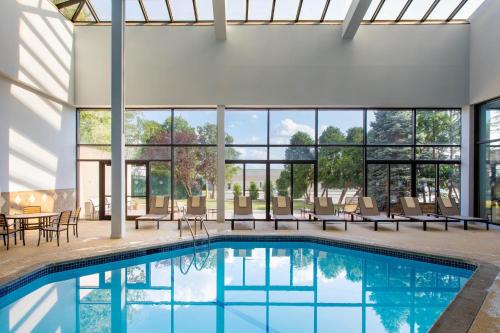 a large pool with chairs and tables and windows at Sheraton Edison in Edison