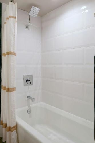 a white bathroom with a tub and a shower at Kansas City Airport Marriott in Kansas City