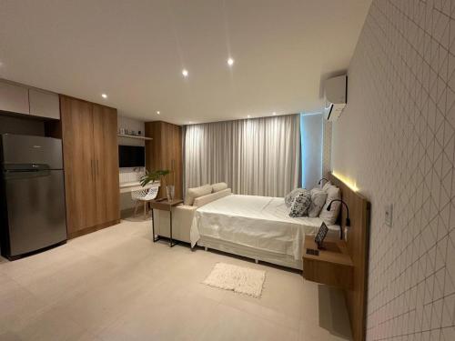 a large bedroom with a bed and a kitchen at Luxuoso flat na praia de Itaipuacu in Maricá