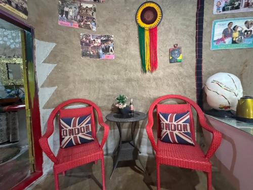two red chairs in a room with a table at Clay House Chiang Mai By Alphatel in Chiang Mai