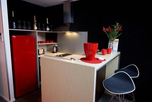 a kitchen with a refrigerator, sink, and counter top at Hôtel du Centre in Noumea