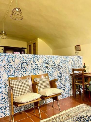 a room with two chairs and a wall with blue and white tiles at La casa nel Borgo in Fiano Romano