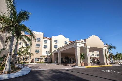 vista sulla parte anteriore di un hotel con palme di TownePlace Suites by Marriott Boynton Beach a Boynton Beach