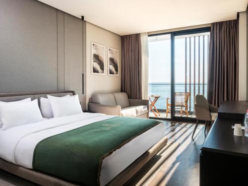 a hotel room with a bed and a view of the ocean at La Brisa Boutique Hotel in Dhërmi