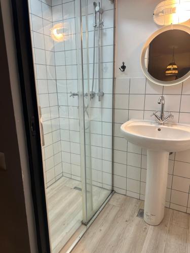a bathroom with a glass shower and a sink at Marvellous 2 Bedrooms Attic in the Old Town in Bucharest
