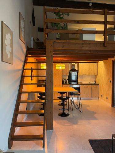 une cuisine ouverte et une salle à manger avec une mezzanine en bois dans l'établissement MH Logement - Escapade aux Arènes, à Nîmes