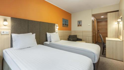 a hotel room with two beds and a chair at Wellton Riga Hotel & SPA in Rīga
