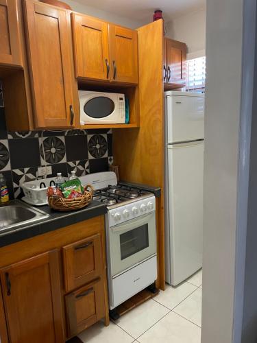 a kitchen with a white stove and a microwave at Albury's Haven in Nassau