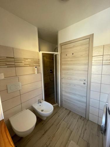 een badkamer met een toilet, een wastafel en een douche bij Bellaria Apartment Mountain View in Predazzo