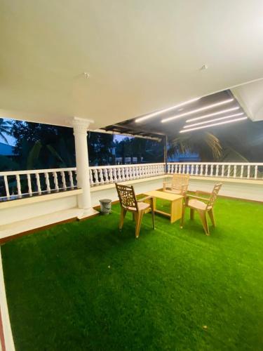 a room with a table and chairs on a balcony at Berghof villa Rooms in Cochin