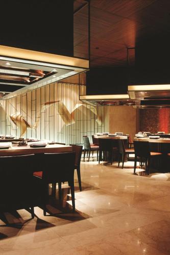 a dining room with tables and chairs and lights at JW Marriott Hotel Bangkok in Bangkok