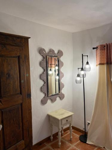 a room with a mirror and a lamp and a table at La Magnanerie en Provence in Niozelles