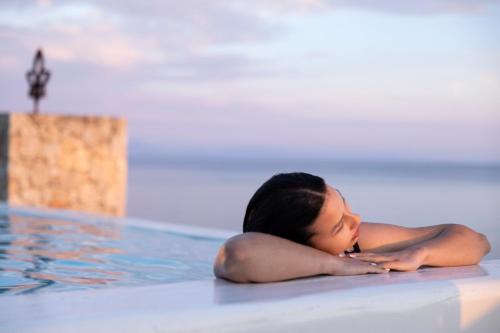 a woman laying in a swimming pool at La Brisa Boutique Hotel in Dhërmi