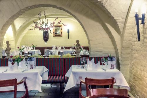 a restaurant with two tables with white tablecloths at Hotel Schloss Neustadt-Glewe in Neustadt-Glewe