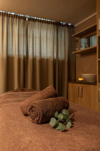 a bed with two towels and a plant on it at Wellton Riga Hotel & SPA in Rīga
