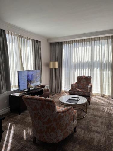 a living room with a couch and chairs and a television at Luxury Residence at Taj Cape Town - Top Corner Apartment with Balcony in Cape Town