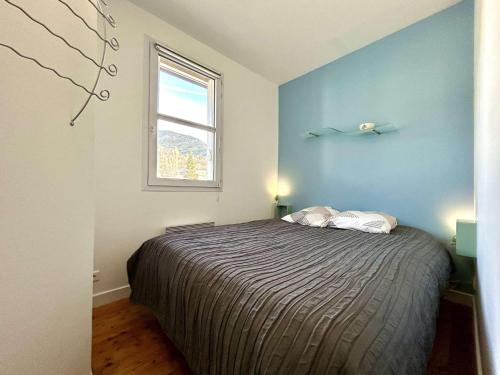 a bedroom with a bed with a blue wall at Duplex 70m² 8 pers. à Briançon, proche télécabine, 2 chambres, coin nuit, parking privé - FR-1-330C-1 in Briançon