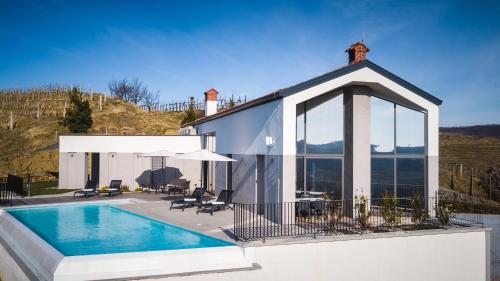 a villa with a swimming pool and a house at Larya House in Dobrovo