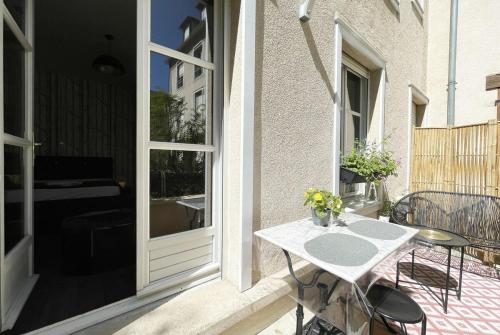 un patio avec une table et des chaises sur un balcon dans l'établissement Mon jardin d'Eden, à Chartres