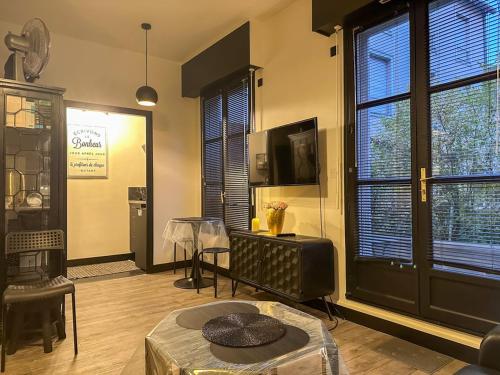 - un salon avec une table et quelques fenêtres dans l'établissement Mon jardin d'Eden, à Chartres