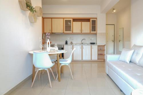 a kitchen and living room with a table and a couch at Pnoé Luminous Apartment in Nafplio