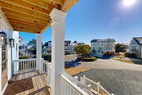 a porch of a home with a white fence at Beach Hunters in Holden Beach