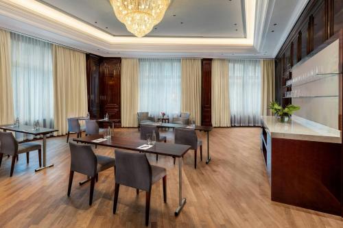 a dining room with tables and chairs and a chandelier at The Ritz-Carlton, Berlin in Berlin