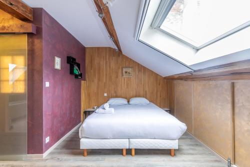 une chambre avec un lit et une lucarne dans l'établissement Ultra centre, 2 Ch, 2 SDB, Blois, à Blois