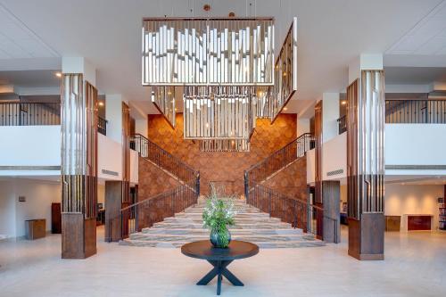 a lobby with a staircase and a large chandelier at Sheraton Eatontown Hotel in Eatontown