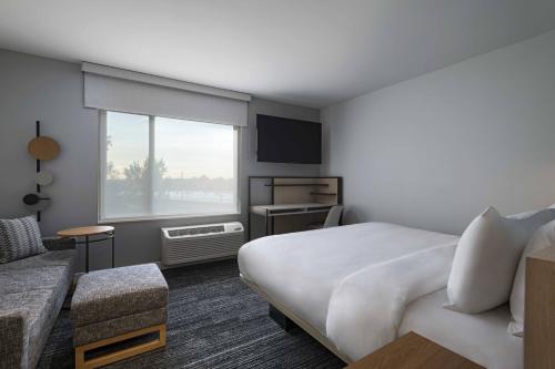 a hotel room with a bed and a couch at TownePlace Suites by Marriott Brentwood in Brentwood